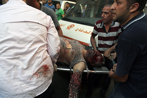 Men carry the corpse of a civilian who was killed in the Roweis explosion Photo Report: Deadly Terrorist Blast Rocks Beirut’s Dahiyeh