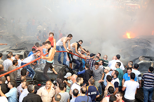 People help in extinguishing fire at the scene of the Roweis explosion Photo Report: Deadly Terrorist Blast Rocks Beirut’s Dahiyeh