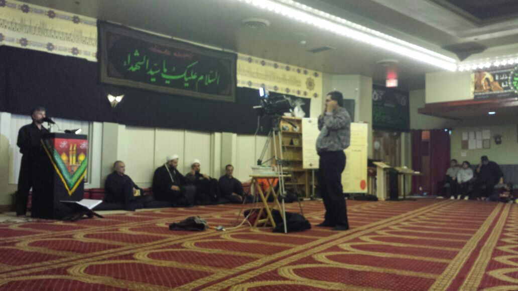 Speaker at a mosque in Ottawa being filmed Ashoura in Canada: Reviving the Meaning of Humanity through a Simple Message