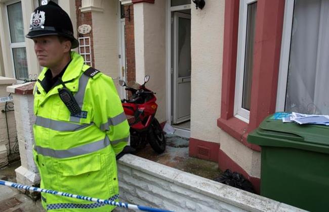 A police officer stands outside a house in Portsmouth, southern England 
