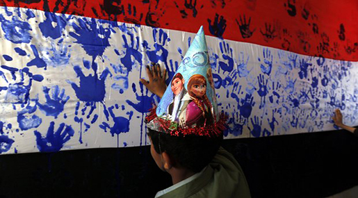 Boy painting hand on Yemeni flag