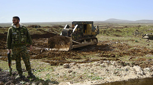 Syrian soldier standing next to a bulldozer in Deraa