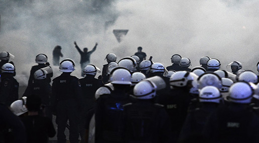 Bahraini police and protesters amidst teargas