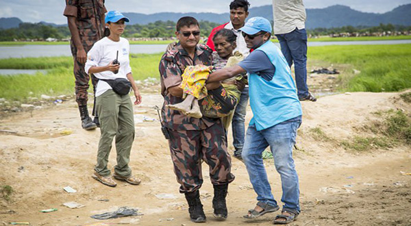 BGB Major Ashikur Rahim carries an elderly woman from no man's land near Anjumpara border to a safe place after she fell to the ground